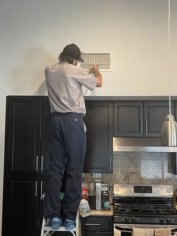 Technician inspecting an air vent during HVAC service in Unionville